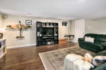 This basement living area features a large entertainment unit with a flat-screen TV and ample storage for media.