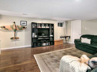 This basement living area features a large entertainment unit with a flat-screen TV and ample storage for media.