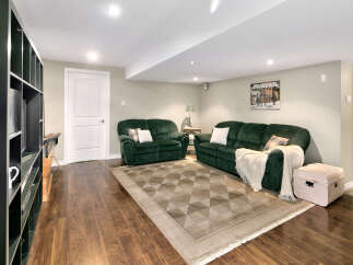 This inviting basement living area features two plush green sofas, perfect for relaxing or entertaining.