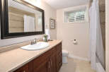 This charming bathroom features a spacious vanity with ample storage, a clean white sink, and a large mirror.