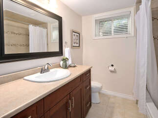 This charming bathroom features a spacious vanity with ample storage, a clean white sink, and a large mirror.