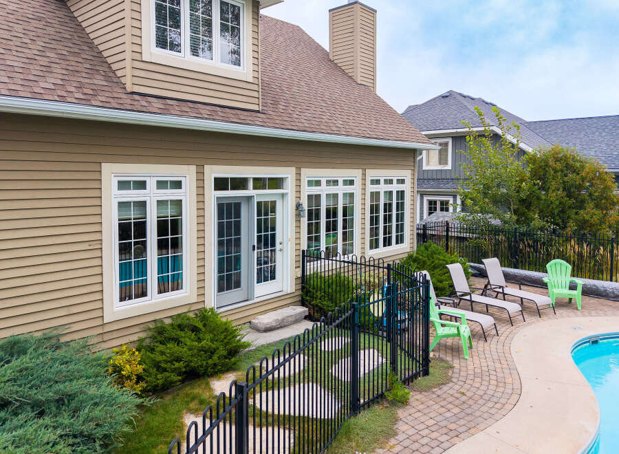 Enjoy outdoor living with this stunning backyard featuring a sparkling swimming pool and ample lounge seating.