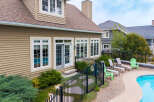 Enjoy outdoor living with this stunning backyard featuring a sparkling swimming pool and ample lounge seating.