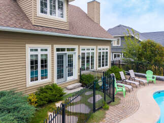 Enjoy outdoor living with this stunning backyard featuring a sparkling swimming pool and ample lounge seating.