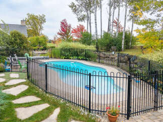 Enjoy the beauty of autumn with this stunning backyard oasis, complete with a sparkling blue pool perfect for relaxation and recreation.