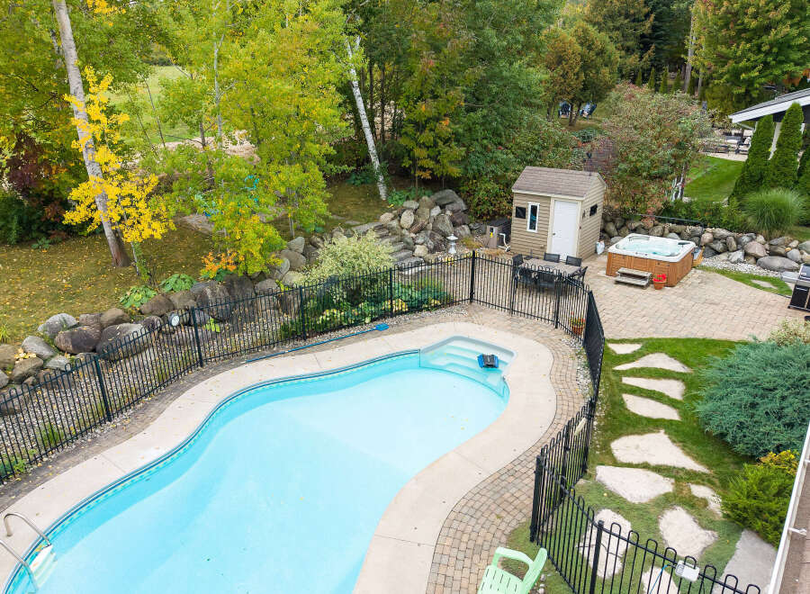 Enjoy outdoor living at its finest with this stunning backyard oasis, featuring a sparkling swimming pool and a relaxing hot tub.