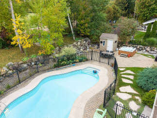 Enjoy outdoor living at its finest with this stunning backyard oasis, featuring a sparkling swimming pool and a relaxing hot tub.
