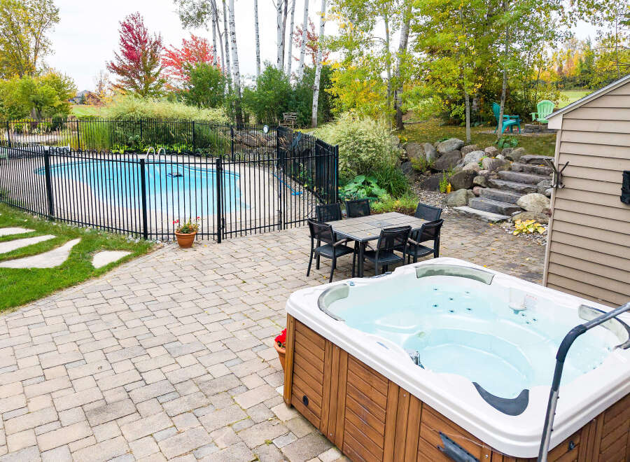 Enjoy outdoor living at its finest with this backyard oasis, featuring a sparkling swimming pool and a relaxing hot tub.