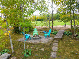 Enjoy cozy evenings around the fire pit in this charming backyard oasis.