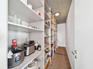 Discover ample storage in this well-organized pantry, featuring extensive shelving for all your kitchen essentials.