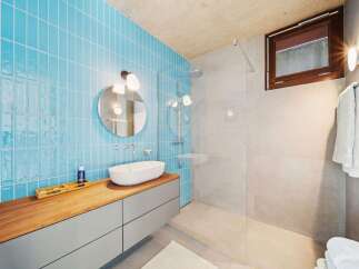 Experience modern luxury in this stunning bathroom, featuring vibrant blue subway tiles that create a striking accent wall.