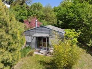 Nestled amidst lush greenery, this charming modern cabin offers a serene retreat.