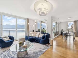 Experience breathtaking lake and mountain views from this stunning modern living room.