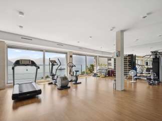 Experience a luxurious workout with a stunning lake and mountain view from this state-of-the-art home gym.