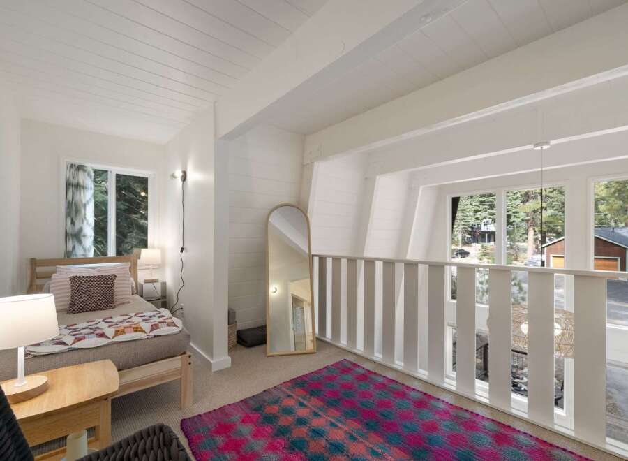 This charming loft bedroom features a cozy twin bed adorned with a colorful quilt and decorative pillows.