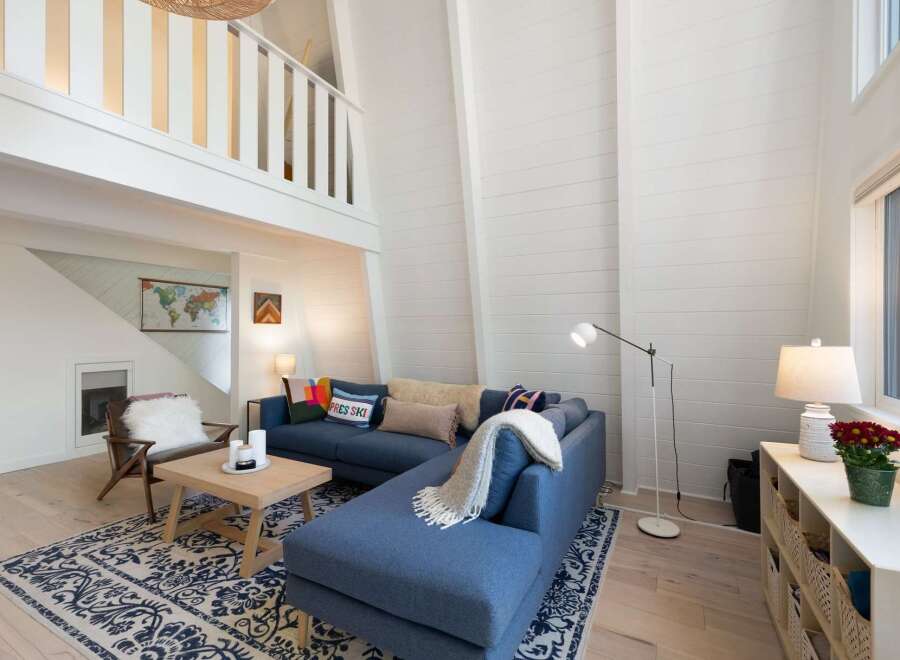 Experience the ultimate in modern living with this stunning living room featuring a spacious blue sectional sofa and a cozy armchair.