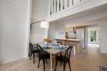 Experience bright and airy living in this charming dining area, featuring a light wood table set for four and elegant black chairs.