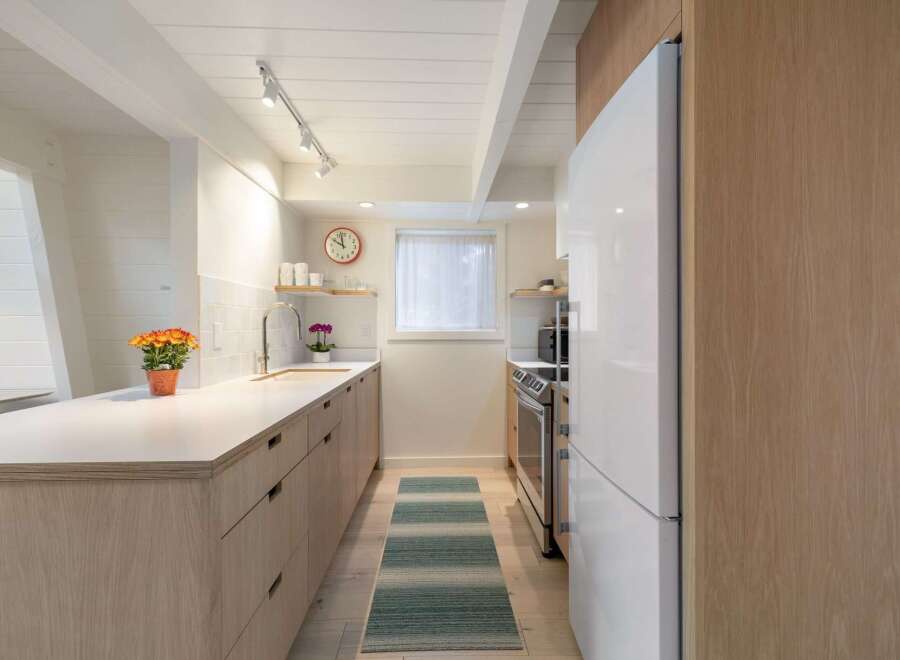 This modern kitchen boasts sleek, light wood cabinetry and a clean white countertop, creating a bright and airy atmosphere.