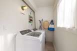This laundry room boasts a modern Whirlpool top-load washer and dryer, perfect for handling family-sized loads.