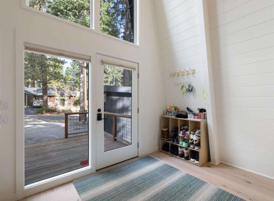 Step into this bright and airy entryway, featuring a soaring ceiling and large windows that flood the space with natural light.