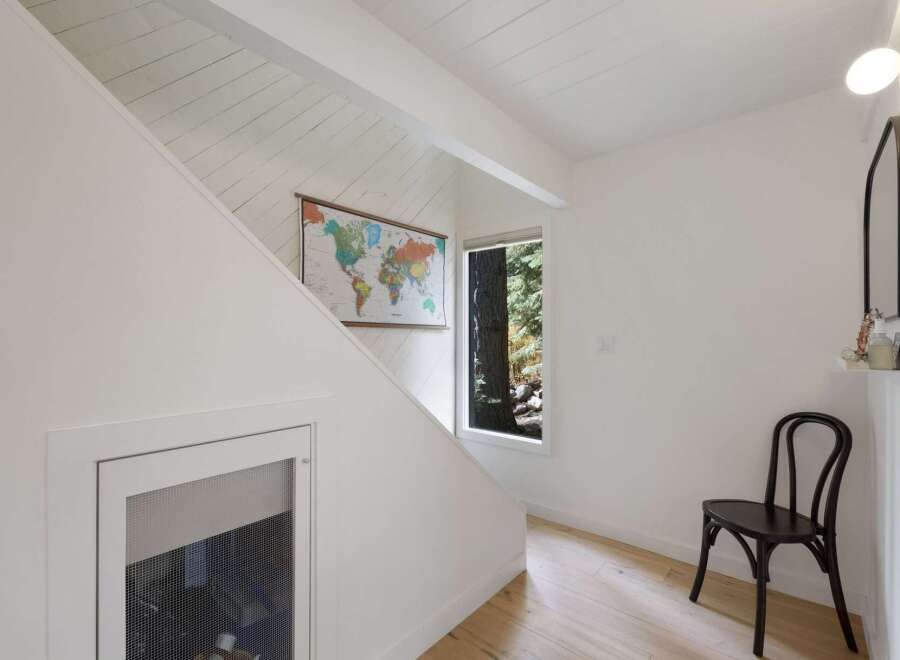 Discover this charming entryway featuring a world map accentuating the sloped, shiplap ceiling and a unique under-stair storage access.