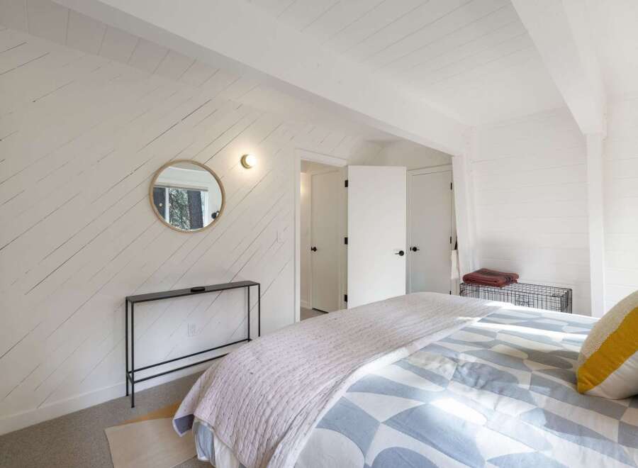This bedroom features a unique accent wall with white shiplap siding, adding a rustic charm.