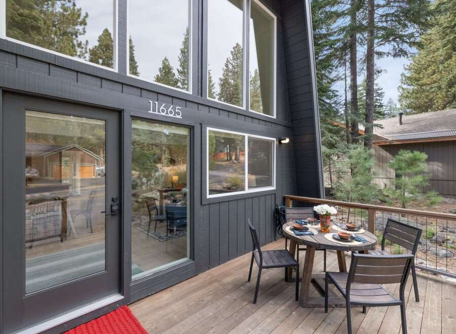 Experience mountain living at its finest with this stunning A-frame home, featuring a modern dark exterior and expansive windows that invite the surrounding forest indoors.