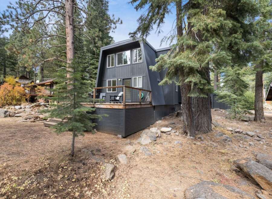 Nestled amongst tall pine trees, this modern A-frame home offers a serene mountain retreat.