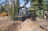 Nestled amongst tall pine trees, this modern A-frame home offers a serene mountain retreat.