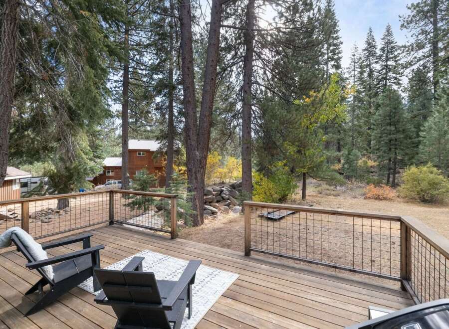 Enjoy the serene mountain lifestyle from this spacious deck, perfect for outdoor entertaining or quiet relaxation amidst the tall pines.