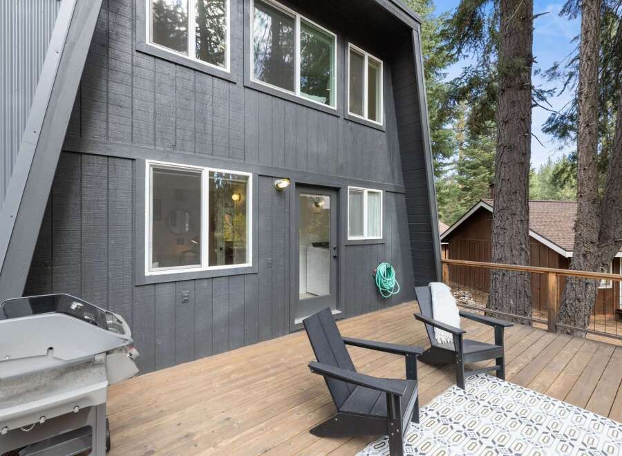 Enjoy outdoor living on this spacious wooden deck, perfect for entertaining or relaxing amidst the serene natural surroundings.