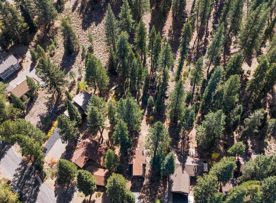 Discover this charming property nestled amongst towering pine trees, offering a serene and private retreat.
