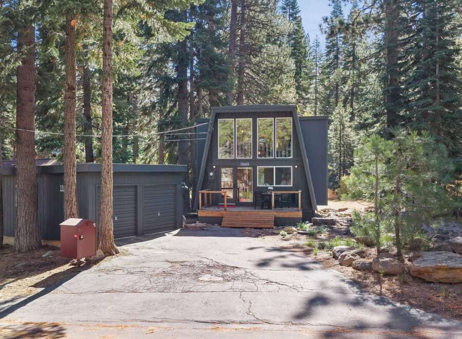 Discover this charming A-frame home nestled among tall pine trees, offering a unique architectural style and a serene forest setting.