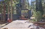 Discover this charming A-frame home nestled among tall pine trees, offering a unique architectural style and a serene forest setting.