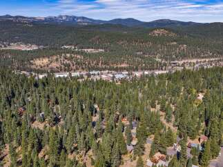 Nestled amidst a dense forest of towering pine trees, this property offers a serene and private mountain retreat.