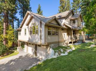 Nestled amidst tall pine trees, this stunning multi-story home offers a picturesque retreat.
