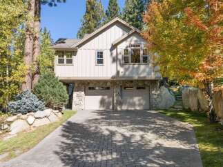 Nestled amidst mature trees with vibrant autumn foliage, this charming home offers a picturesque setting.