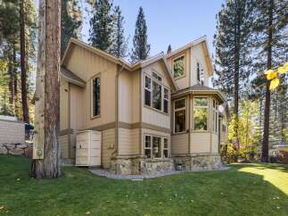 Nestled amongst tall pine trees, this charming home offers a unique blend of rustic and modern living.