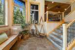 Step into this inviting entryway featuring a rustic wooden bench and lush greenery, perfect for welcoming guests.