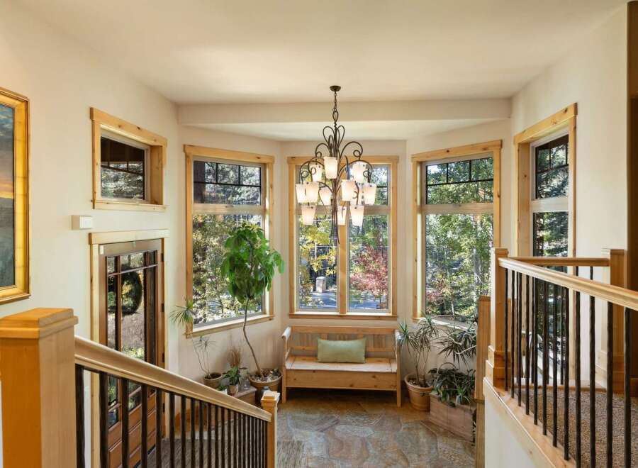 Step into this inviting entryway featuring a beautiful bay window that floods the space with natural light, offering picturesque views of the surrounding autumn foliage.