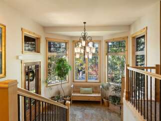 Step into this inviting entryway featuring a beautiful bay window that floods the space with natural light, offering picturesque views of the surrounding autumn foliage.