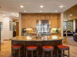 This spacious kitchen boasts custom wood cabinetry and a large granite island, perfect for entertaining.
