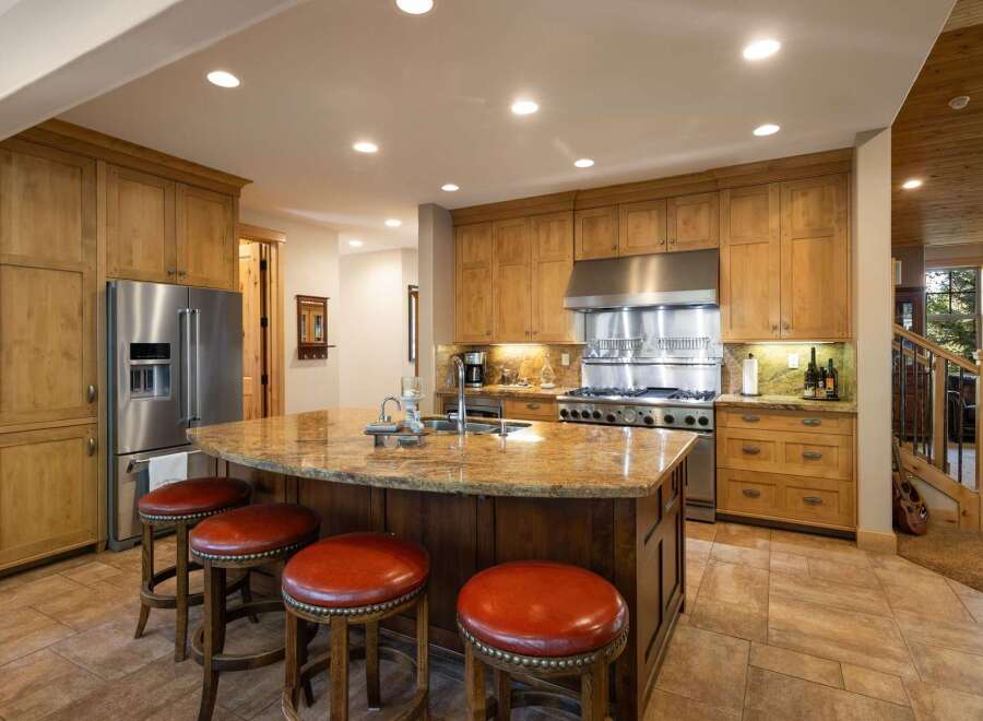 This spacious kitchen boasts custom wood cabinetry and a large granite island, perfect for entertaining.