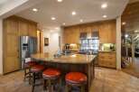 This spacious kitchen boasts custom wood cabinetry and a large granite island, perfect for entertaining.