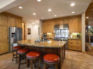 This spacious kitchen boasts custom wood cabinetry and a large granite island, perfect for entertaining.