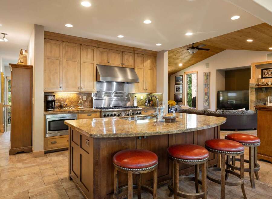 This spacious kitchen boasts a large granite island with comfortable seating, perfect for casual dining or entertaining guests.