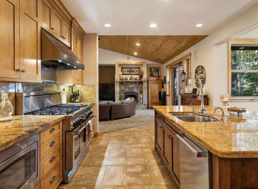Experience the warmth and elegance of this stunning kitchen, featuring a professional-grade gas range and a spacious granite island with a double sink.