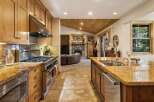 Experience the warmth and elegance of this stunning kitchen, featuring a professional-grade gas range and a spacious granite island with a double sink.