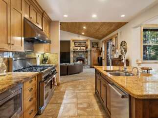 Experience the warmth and elegance of this stunning kitchen, featuring a professional-grade gas range and a spacious granite island with a double sink.
