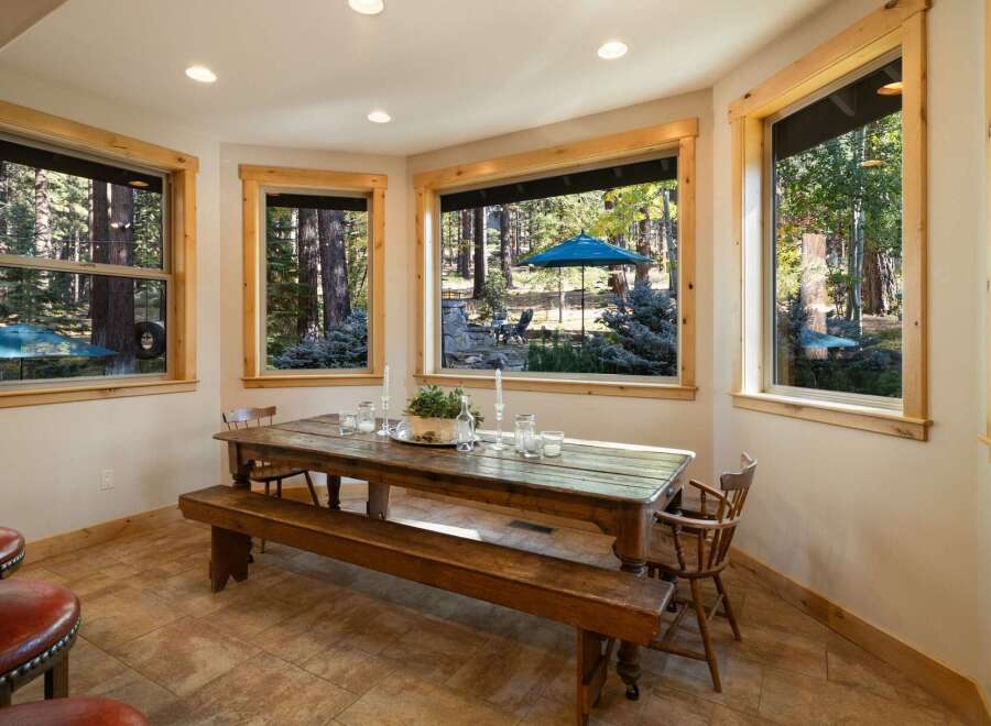 Enjoy breathtaking forest views from this charming dining area, featuring a rustic wooden table and bench perfect for intimate gatherings.